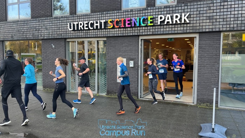 Enthousiaste hardlopers door de gebouwen tijdens de Utrecht Science Park Campus Run